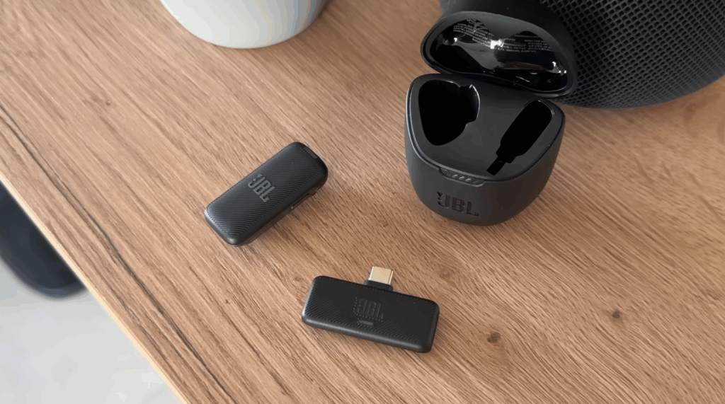 JBL Bluetooth Adapter und kabelloses Mikrofon auf einem Holztisch.