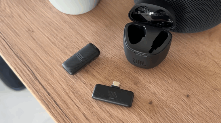 JBL Bluetooth Adapter und kabelloses Mikrofon auf einem Holztisch.