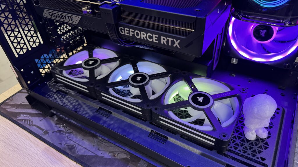 Drei RGB-Lüfter in einem Computer-Gehäuse mit einer GeForce RTX Grafikkarte und einem Asus Mainboard.